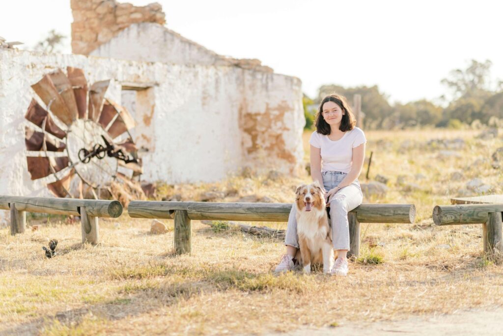 Mya and her pup, Olive, sitting on a bench in the field of Yellagonga Regional Park.
